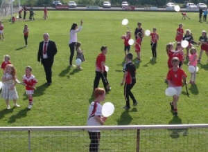 YOUNG CHILDREN RELEASE WHITE BALLOONS IN MEMORY OF DECEASED MEMBERS